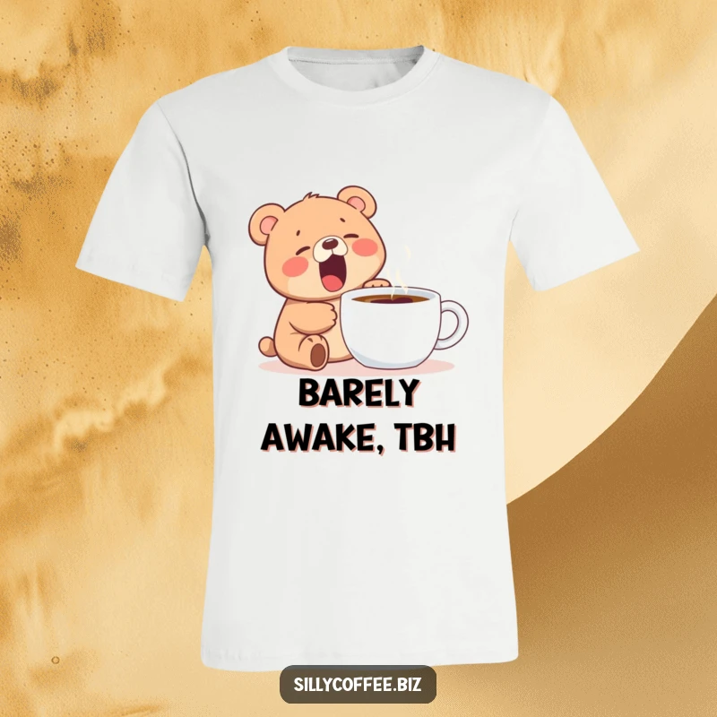 Funny t-shirt displaying a kawaii bear cub yawning widely beside a steaming coffee mug, perfect for coffee lovers.